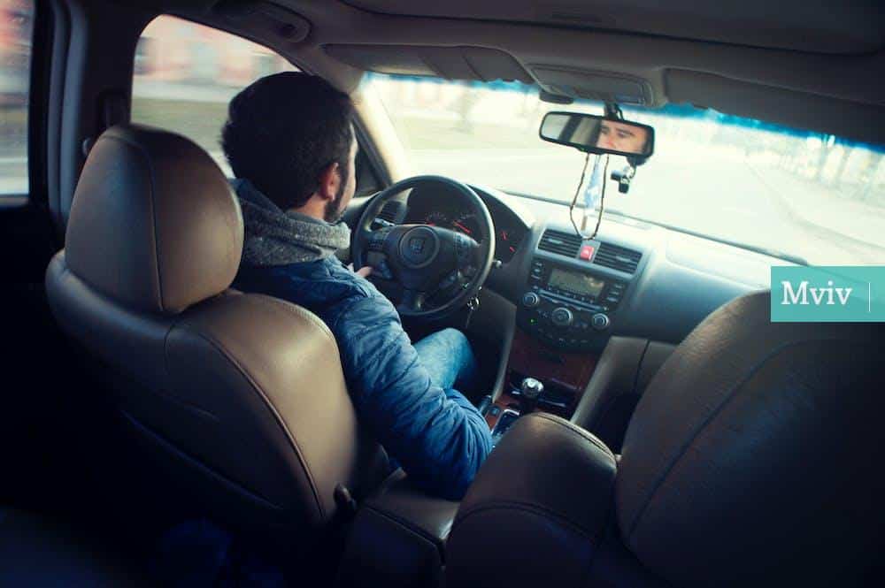 Man Wearing Blue Jacket Sitting Inside Car While Driving